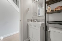 Bathroom with tasteful backsplash, vanity, and light wood-style flooring - 