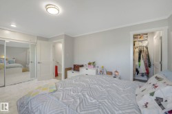 Bedroom featuring ornamental molding, light colored carpet, and a spacious closet - 
