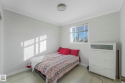 Bedroom featuring crown molding, wood walls, and light wood-style flooring - 