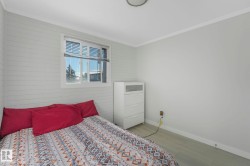 Bedroom featuring ornamental molding, wood finished floors, and wooden walls - 