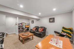 Living area featuring light colored carpet, wooden walls, recessed lighting, and ornamental molding - 