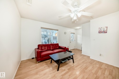 Living area with light wood-style flooring and ceiling fan - #48 - 2503 24 Street Nw, Edmonton, AB - Indoor Photo Showing Living Room