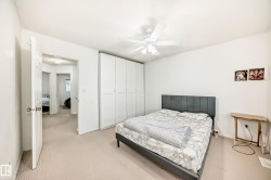 Carpeted bedroom featuring ceiling fan and a closet - 