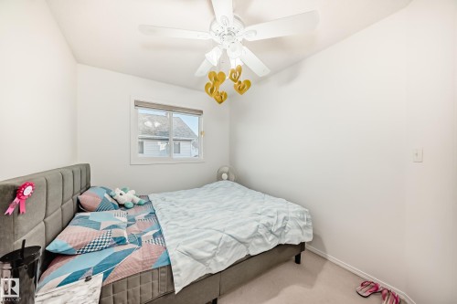 Carpeted bedroom featuring a ceiling fan and baseboards - #48 - 2503 24 Street Nw, Edmonton, AB - Indoor Photo Showing Bedroom