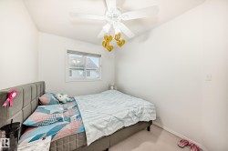 Carpeted bedroom featuring a ceiling fan and baseboards - 