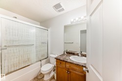 Full bath featuring vanity, a textured ceiling, and enclosed tub / shower combo - 