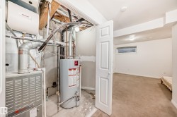 Utility room featuring gas water heater and heating unit - 