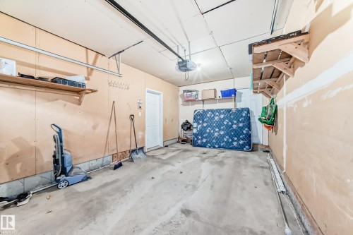 Garage with a garage door opener - #48 - 2503 24 Street Nw, Edmonton, AB - Indoor Photo Showing Garage