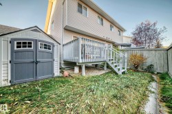 Rear view of property with a deck, board and batten siding, a storage shed, stairway, and a fenced backyard - 