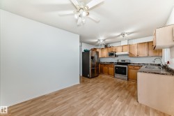 Kitchen featuring appliances with stainless steel finishes, light wood-type flooring, under cabinet range hood, and ceiling fan - 