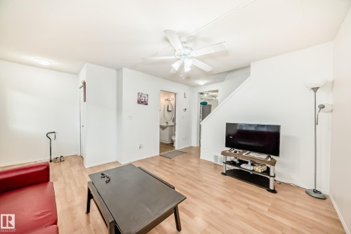 Living room featuring light wood-style flooring and ceiling fan - #48 - 2503 24 Street Nw, Edmonton, AB - Indoor