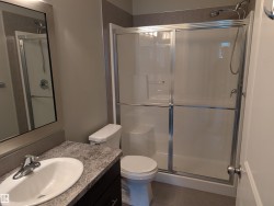 Bathroom featuring a shower stall, vanity, and tile - 