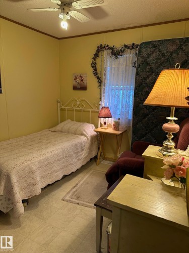 Bedroom featuring a textured ceiling, ornamental molding, and a ceiling fan - 37 43 Avenue, Millet, AB - Indoor Photo Showing Bedroom