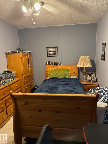 Bedroom with a textured ceiling and ceiling fan - 37 43 Avenue, Millet, AB - Indoor
