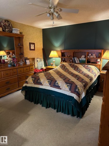 Bedroom with a ceiling fan, a textured ceiling, and carpet - 37 43 Avenue, Millet, AB - Indoor Photo Showing Bedroom