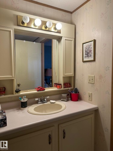 Bathroom featuring wallpapered walls, vanity, crown molding, and a textured ceiling - 37 43 Avenue, Millet, AB - Indoor Photo Showing Bathroom