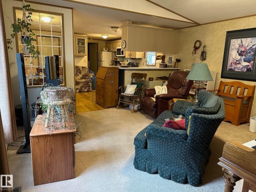 Living area with a textured ceiling, crown molding, light carpet, and vaulted ceiling - 37 43 Avenue, Millet, AB - Indoor Photo Showing Living Room