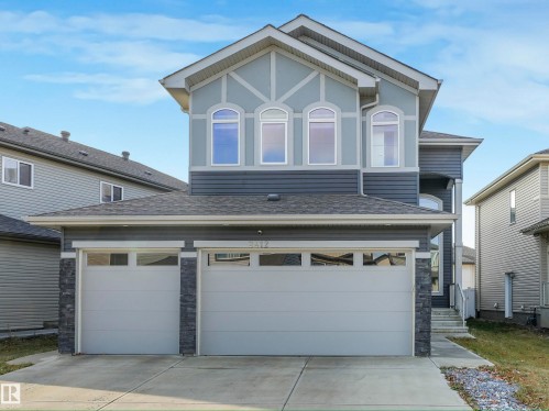 View of front facade featuring concrete driveway, a shingled roof, stone siding, stucco siding, and a garage - 2412 14 Avenue, Edmonton, AB - Outdoor With Facade