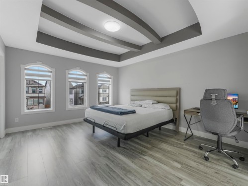 Bedroom with a tray ceiling, beam ceiling, and light wood-style floors - 2412 14 Avenue, Edmonton, AB - Indoor Photo Showing Bedroom