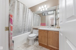 Full bath featuring vanity, shower / bath combination with curtain, and light tile patterned floors - 