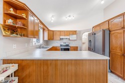 Kitchen with arched walkways, light countertops, open shelves, a peninsula, and appliances with stainless steel finishes - 