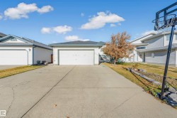 View of front of house with driveway, a front yard, and an attached garage - 
