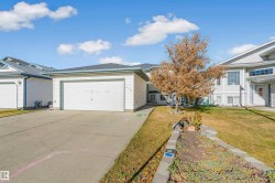 View of front of property featuring a front yard, concrete driveway, and a garage - 