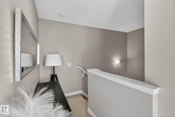 Corridor featuring an upstairs landing and light colored carpet - 