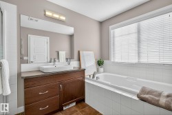 Full bath with vanity, a bath, and dark tile patterned floors - 