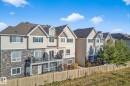 Back of property with a residential view, stone siding, a balcony, and a shingled roof - 117 7293 South Terwillegar Drive, Edmonton, AB  - Outdoor With Facade 