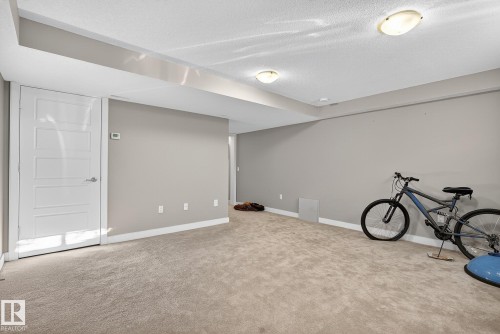 Finished basement with a textured ceiling and light carpet - 117 7293 South Terwillegar Drive, Edmonton, AB - Indoor