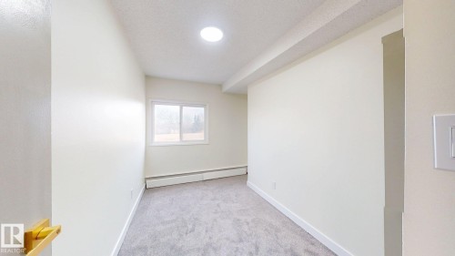 Spare room with light colored carpet, a baseboard radiator, and a textured ceiling - 114 2908 116A Avenue, Edmonton, AB - Indoor Photo Showing Other Room