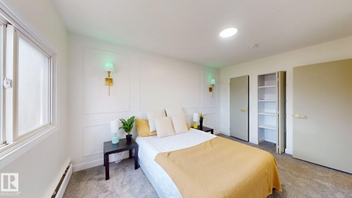 Bedroom featuring a baseboard heating unit, a decorative wall, and light colored carpet - 114 2908 116A Avenue, Edmonton, AB - Indoor Photo Showing Bedroom