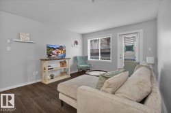 Living room with a textured ceiling and dark wood-type flooring - 