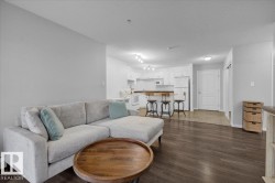 Living area featuring dark wood-type flooring and a textured ceiling - 