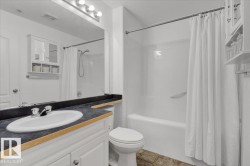 Bathroom featuring shower / bath combination with curtain, vanity, light tile patterned floors, and a textured ceiling - 