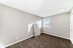 Unfurnished room featuring dark colored carpet and baseboards - 