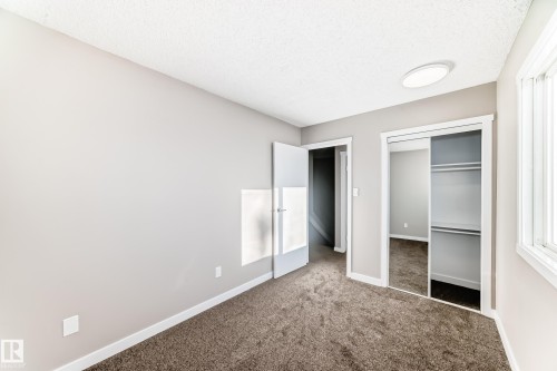 Unfurnished bedroom featuring carpet flooring, a textured ceiling, and a closet - 44 4403 Riverbend Road, Edmonton, AB - Indoor Photo Showing Other Room