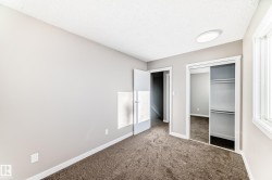 Unfurnished bedroom featuring carpet flooring, a textured ceiling, and a closet - 