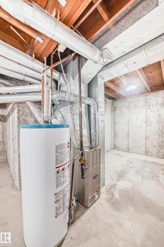 Utility room featuring gas water heater and heating unit - 44 4403 Riverbend Road, Edmonton, AB - Indoor Photo Showing Basement