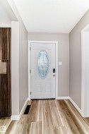 Entrance foyer with a textured ceiling and light wood-style flooring - 