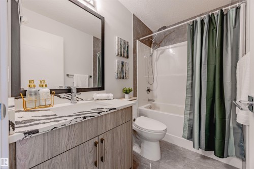 Bathroom with a textured ceiling, shower / tub combo, and vanity - 8086 Kiriak Link, Edmonton, AB - Indoor Photo Showing Bathroom
