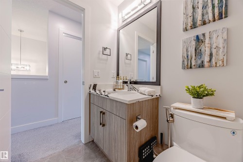 Half bathroom featuring vanity, light tile patterned flooring, and light colored carpet - 8086 Kiriak Link, Edmonton, AB - Indoor Photo Showing Bathroom