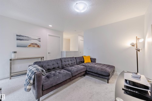 Carpeted living area featuring a textured ceiling and recessed lighting - 8086 Kiriak Link, Edmonton, AB - Indoor Photo Showing Living Room