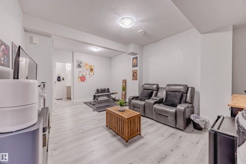 Living room with a textured ceiling and light wood-style floors - 8086 Kiriak Link, Edmonton, AB - Indoor