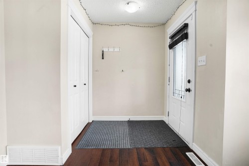 Foyer featuring dark wood finished floors and a textured ceiling - 1442 33A Street Nw, Edmonton, AB - Indoor Photo Showing Other Room