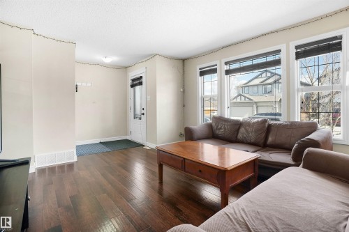 Living area featuring wood-type flooring and a textured ceiling - 1442 33A Street Nw, Edmonton, AB - Indoor Photo Showing Living Room