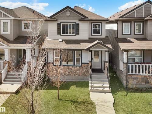 Craftsman-style house featuring stone siding, a front yard, and roof with shingles - 1442 33A Street Nw, Edmonton, AB - Outdoor With Facade