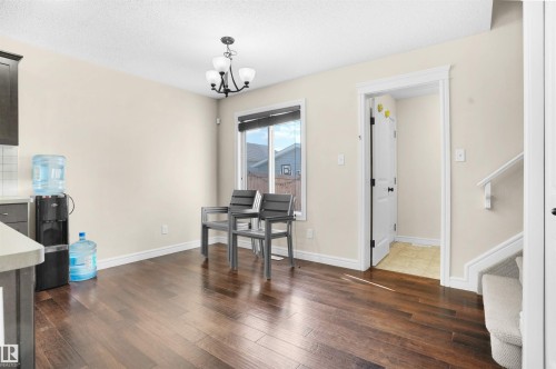 Home office featuring dark wood finished floors, a chandelier, and a textured ceiling - 1442 33A Street Nw, Edmonton, AB - Indoor