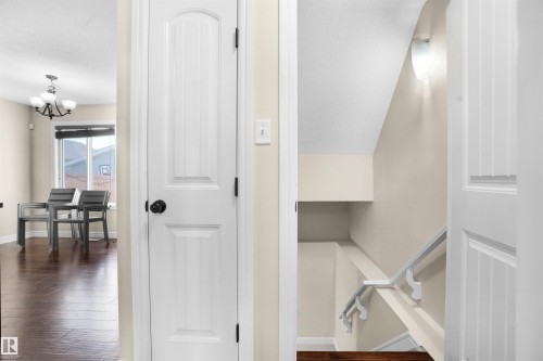 Staircase featuring a textured ceiling, wood finished floors, and a chandelier - 1442 33A Street Nw, Edmonton, AB - Indoor Photo Showing Other Room